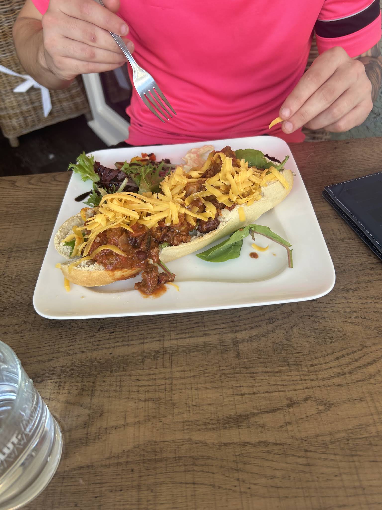 A whole rectangular white lunch plate with a filled baguette and salad photographed at Utopia
